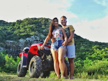 Casal tira foto andando de quadriciclo em Arraial do Cabo em um morro