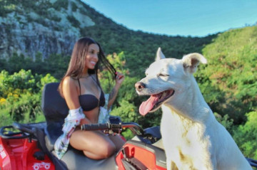 Linda mulher andando de quadriciclo com seu cachorro em um mirante em Arraial do Cabo